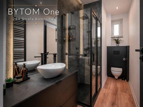 a bathroom with two sinks and a shower at BYTOM One 24H Strefa Komfortu in Bytom