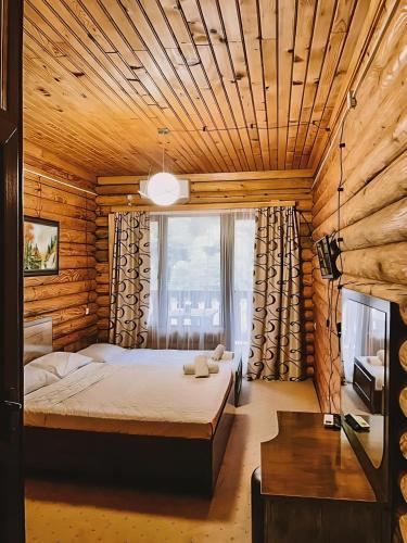 ein Schlafzimmer mit einem Bett in einer Holzhütte in der Unterkunft Hotel Riverwood in Machakhlispiri