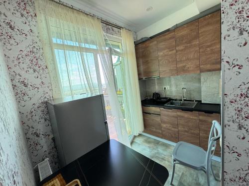 a small kitchen with a table and a refrigerator at Airport Hotel Apartments in Tbilisi City