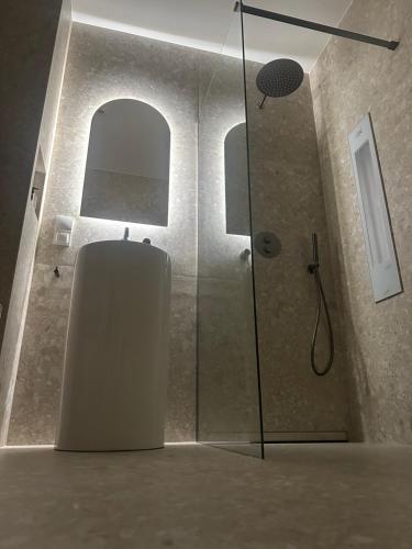 a bathroom with a shower with a tub and a mirror at Port Ostróda 3 - z widokiem na jezioro in Ostróda