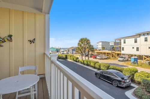 a balcony with a car parked on a street at The Dunes by Oak Island Accommodations in Oak Island