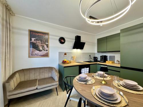 a kitchen and living room with a table and a couch at Studio Jurasz I in Bydgoszcz
