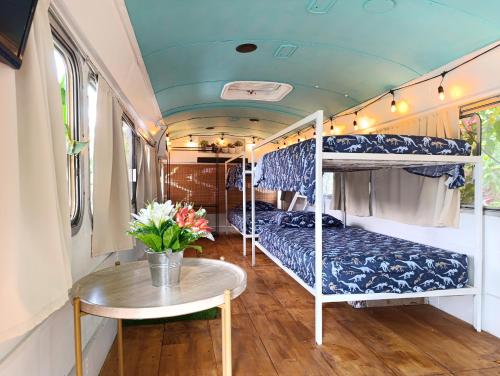 a room with two bunk beds and a table at The Dreamcatcher House Glamping & Cabins Sarchí in Sarchí
