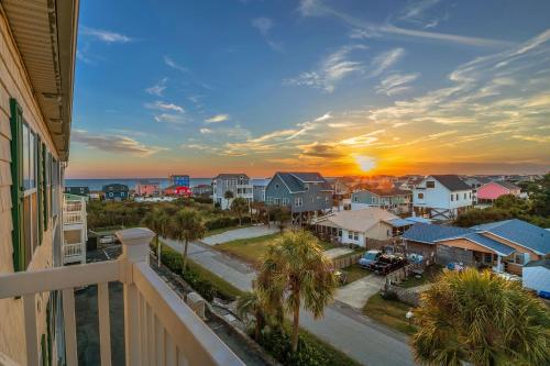 a view from a balcony of a residential neighborhood at sunset at The Island Sandpiper by Oak Island Accommodations in Oak Island