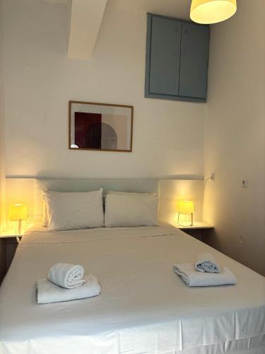a bedroom with a white bed with towels on it at Maria Mare in Myrtos