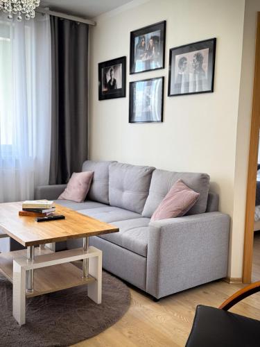 a living room with a couch and a table at Apartament Orange Piastowska in Ostróda