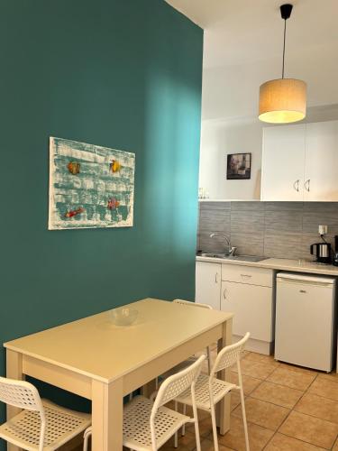 a kitchen with a table and chairs and a blue wall at Maria Mare in Myrtos
