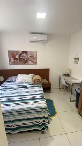 a bedroom with a bed with a striped blanket on it at Casa Condomínio Reserva do Delta in Parnaíba