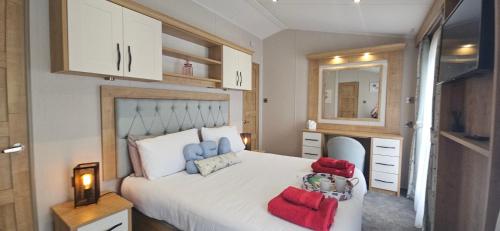 a bedroom with a large white bed and a mirror at The Key is Under the Mat in Polperro