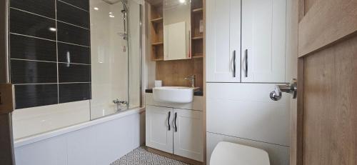 a white bathroom with a sink and a toilet at The Key is Under the Mat in Polperro