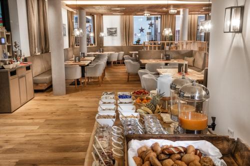 a buffet line with different types of bread and drinks at AlpenParks Hotel & Apartment Orgler Kaprun in Kaprun