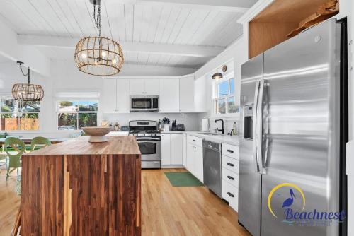 a kitchen with white cabinets and a stainless steel refrigerator at Tiki Tides in Rio Del Mar