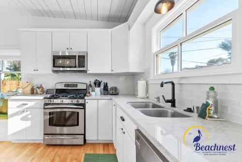 a white kitchen with a sink and a stove at Tiki Tides in Rio Del Mar