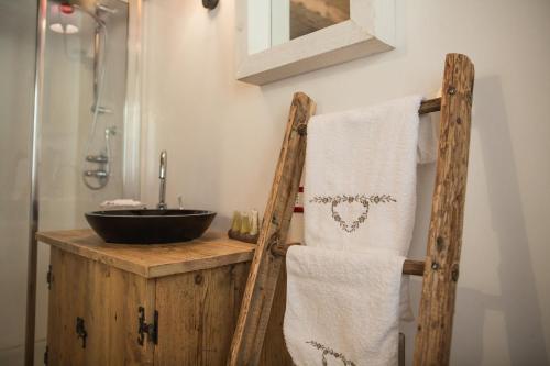 a bathroom with a sink and a wooden towel holder at Maso Del Fieno con Sauna Privata e Vista Unica in Sant'Orsola Terme