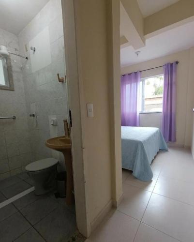 a bathroom with a bed and a shower and a toilet at Apartamento Castelhanos Anchieta in Anchieta