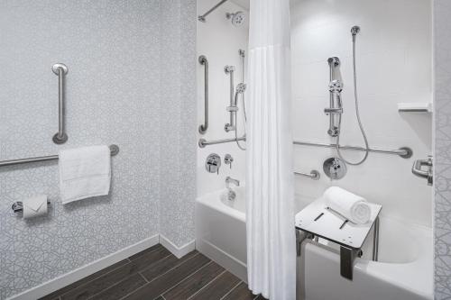a bathroom with a shower and a tub and a sink at Hampton Inn Boston Woburn in Woburn