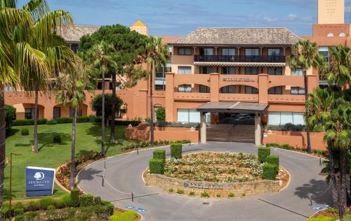 a building with a circular driveway in front of a building at DoubleTree by Hilton Islantilla Beach Golf Resort in Islantilla