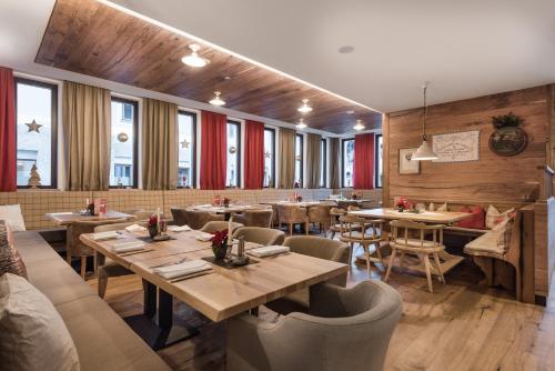 a restaurant with wooden walls and tables and chairs at AlpenParks Hotel & Apartment Orgler Kaprun in Kaprun