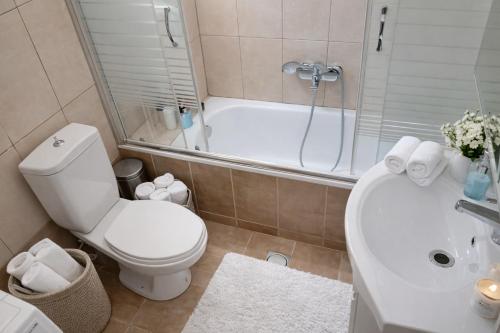 a bathroom with a toilet and a tub and a sink at Epanomi apartment in Epanomi