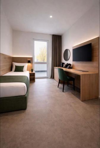 a bedroom with a bed and a desk with a television at Hotel Ks in Bad Fallingbostel