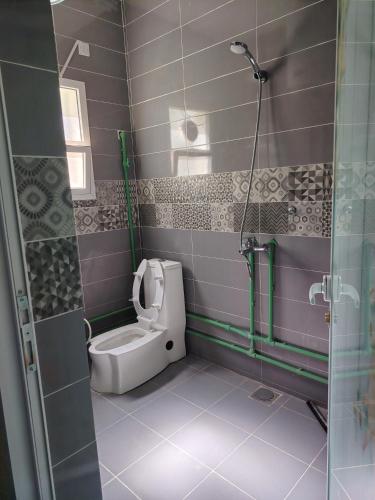 a bathroom with a toilet and a glass shower at Rosa mountain reast in Al ‘Aqar