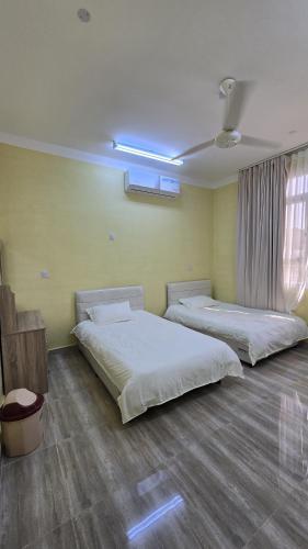 a bedroom with two beds in a room at Rosa mountain reast in Al ‘Aqar
