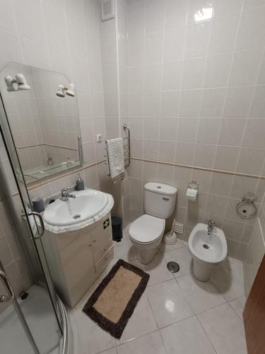 a bathroom with a toilet and a sink at Cantinho da Xica in Lagos