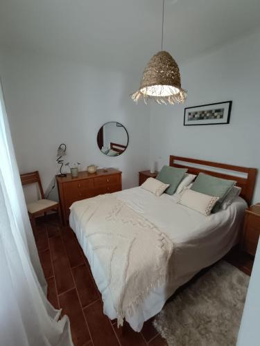 a bedroom with a bed and a mirror at Cantinho da Xica in Lagos