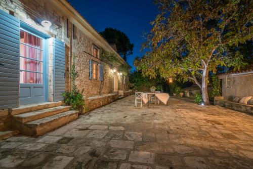 a table and chairs sitting outside of a building at Bratis Holiday Home in Kallithea