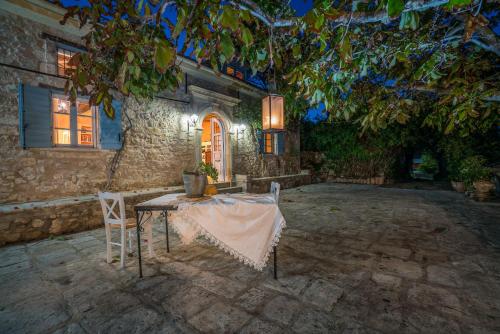 Bratis Holiday Home في Kallithea: طاولة وكراسي أمام المنزل