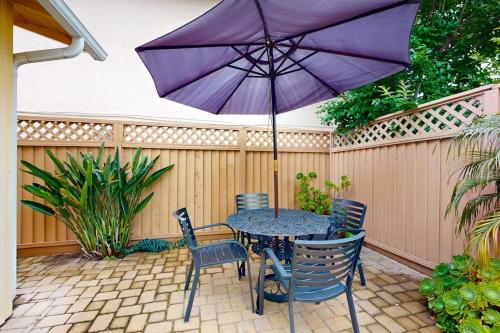 a table with chairs and an umbrella on a patio at Relaxation Station in Corona del Mar