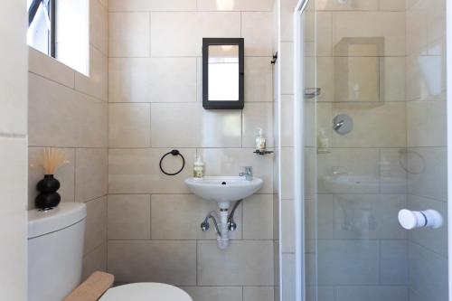 a bathroom with a toilet and a sink and a shower at Stunning Ocean & Mountain View Apartment in Glencairn