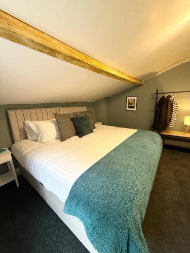 a bedroom with a large white bed with a blue blanket at George Cottage, Alcester in Alcester