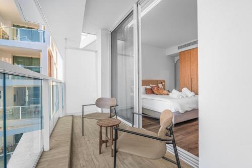a bedroom with a bed and a glass wall at Redsearent front Pool and mountain View in Eilat