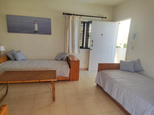 a bedroom with two beds and a window with a lighthouse at Profelia Sea View Apartment in Paralimni