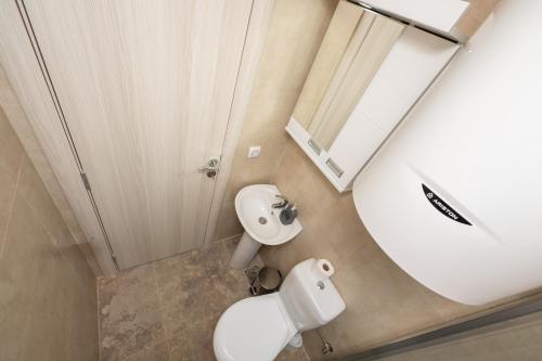 a bathroom with a white toilet and a mirror at Apartmani Dino Kolasin in Kolašin