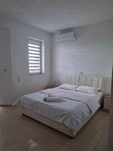 a bedroom with a large white bed with a window at Villa Strmec in Peštani