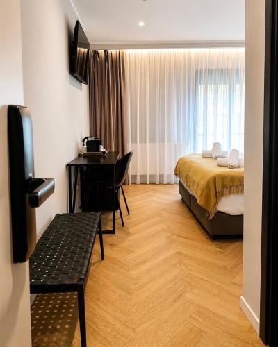 a bedroom with a bed and a desk in a room at NOVO Studio Hotel in Râmnicu Vâlcea