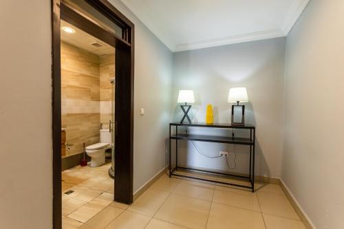 a bathroom with a toilet and two lamps on a table at IZA Serene city centre apartments in Kigali