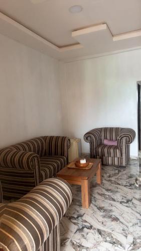 a living room with two couches and a coffee table at Rehoboth place in Awoyaya