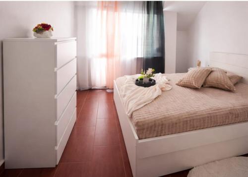 a bedroom with a bed and a dresser with flowers on it at One-Bedroom flat Meden Rudnik zone B in Burgas
