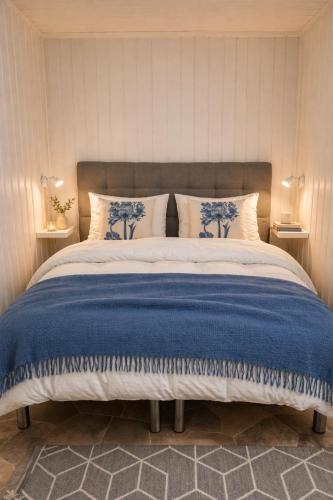 a bedroom with a bed with a blue and white blanket at Nordic Studio - Gravdal, Lofoten in Haug
