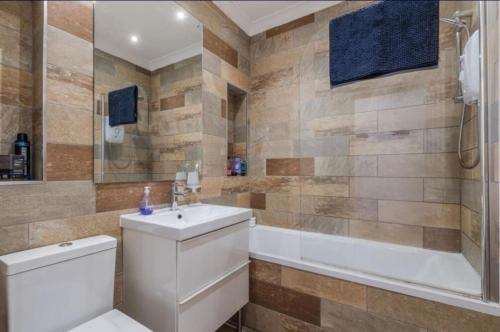 a bathroom with a toilet and a sink and a tub at Blackfriars Cosy Retreat in Glasgow