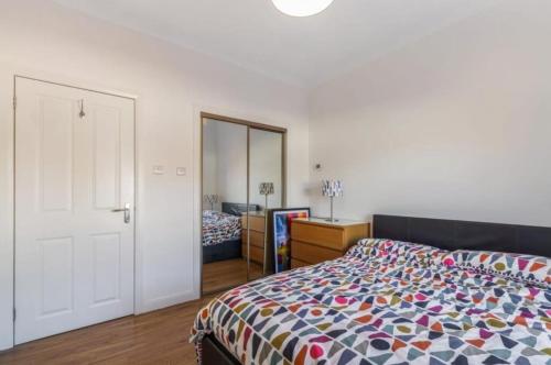 a bedroom with a bed with a colorful comforter at Blackfriars Cosy Retreat in Glasgow
