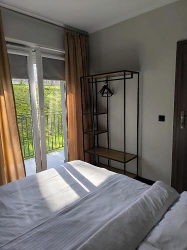 a bedroom with a white bed and a window at Apartament Podmiejska in Jastrzębie Zdrój