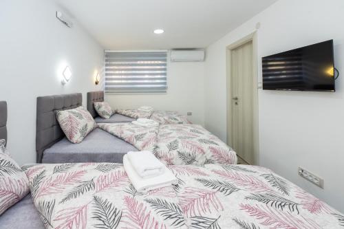 a bedroom with two beds and a flat screen tv at Apartmani Dino Kolasin in Kolašin
