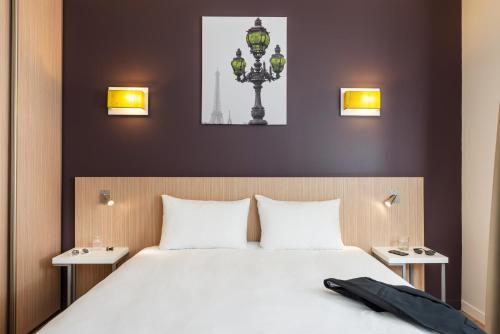 - une chambre avec un lit avec deux tables et une lampe dans l'établissement Aparthotel Adagio Access Paris Clichy, à Clichy