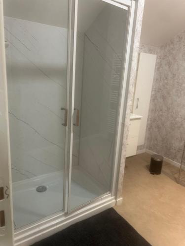 a glass shower stall in a room with at Au Petit Bouchon in Le Breuil