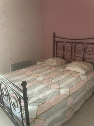a bedroom with a large bed with a metal frame at Au Petit Bouchon in Le Breuil