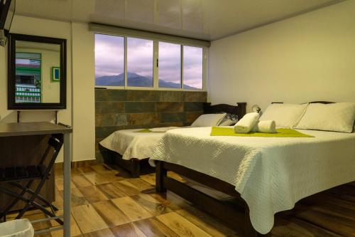a bedroom with two beds and a mirror and a window at Hotel La Floresta Salento in Salento